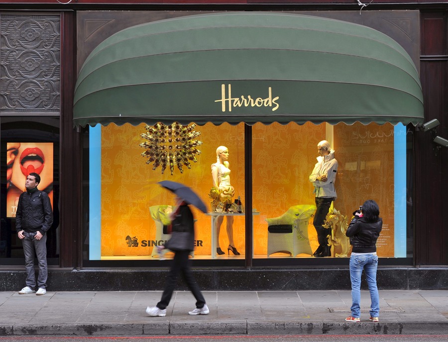 Una mujer fotografía un escaparate de los almacenes Harrods en Londres, Reino Unido.