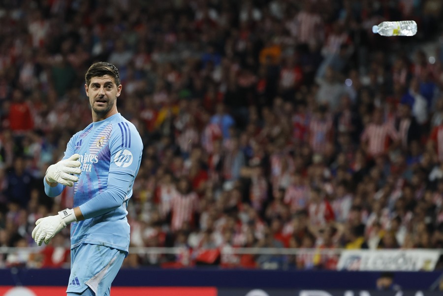 El portero del Real Madrid Thibaut Courtois retira un objeto lanzado desde la grada, durante el partido de la LaLiga EA Sports que Atlético de Madrid y Real Madrid disputan este domingo en el estadio Civitas Metropolitano.