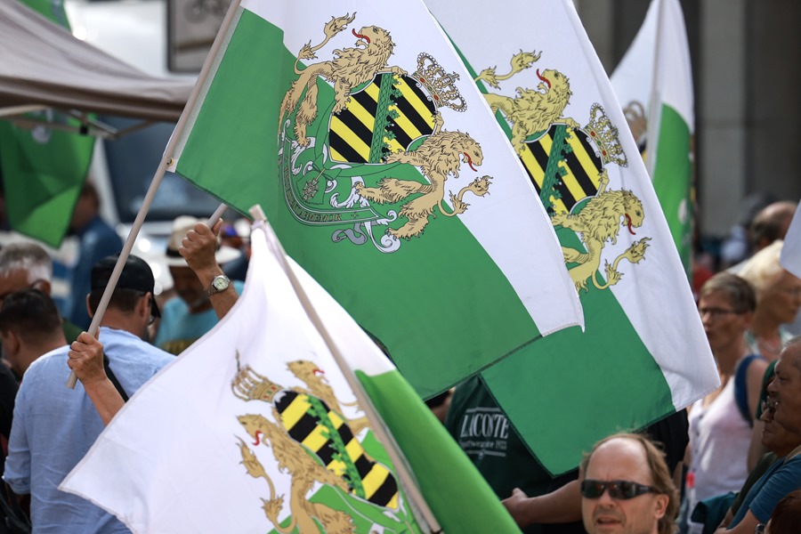 Los manifestantes del movimiento de extrema derecha Sajones libres (Freie Sachsen) ondean banderas mientras se manifiestan antes de un mitin de campaña electoral del Partido Socialdemócrata (SPD) de Sajonia en Chemnitz