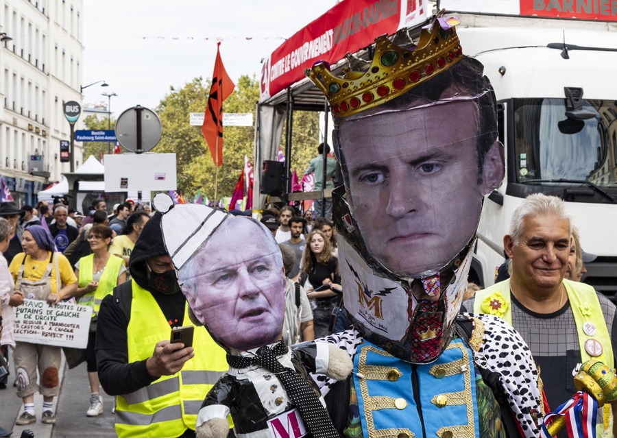 Manifestantes protestan con pancarta contra el primer ministro, Michel Barnier, y el presidente de Francia, Emmanuel Mcaron.