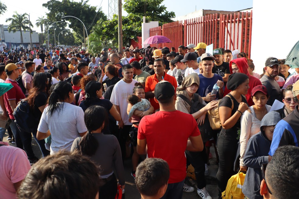 Migrantes esperan afuera de las oficinas migratorias en la ciudad de Tapachula (México), mientras las ONG advierten del aumento de flujo migratorio en la frontera sur de México.