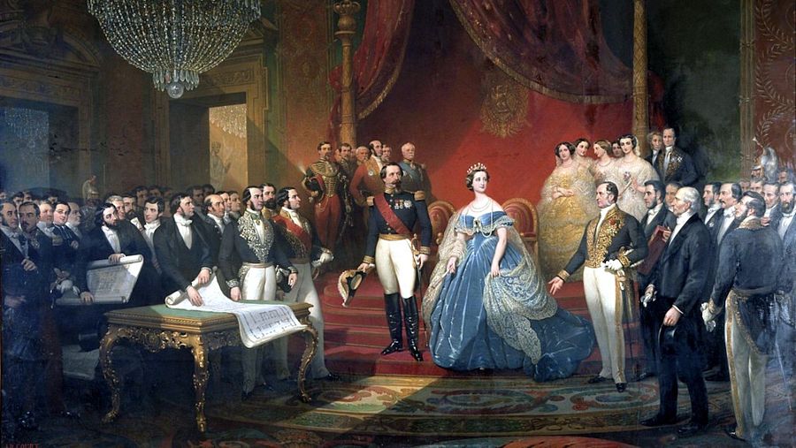 17239459 Napoleón III y Eugenia de Montijo, Emperadores de Francia, posan en el Palacio de Saint Cloud. Él, con uniforme militar; ella, de origen español, con vestido azul y tiara. Cortesanos y documentos completan la escena palaciega.