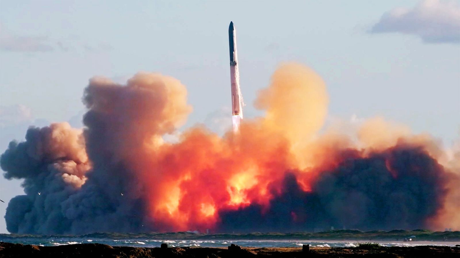 'Documentos TV' estrena 'Los nuevos cowboys del espacio' Un gigantesco cohete espacial se eleva dejando una densa nube de humo y fuego sobre la costa en un día despejado.