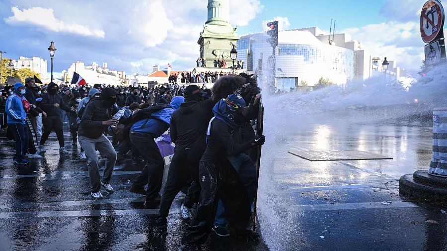 17259744 Manifestantes resisten el cañón de agua de la policía antidisturbios mientras se producen enfrentamientos en la plaza de la Bastilla.