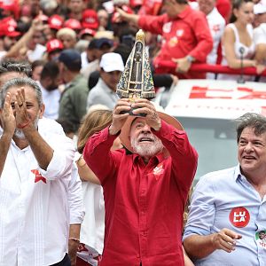 Hora América - Luiz Inácio Lula da Silva sostiene una estatuilla religiosa junto a Elmano de Freitas y Cid Gomes durante un acto político multitudinario en un camión de campaña.